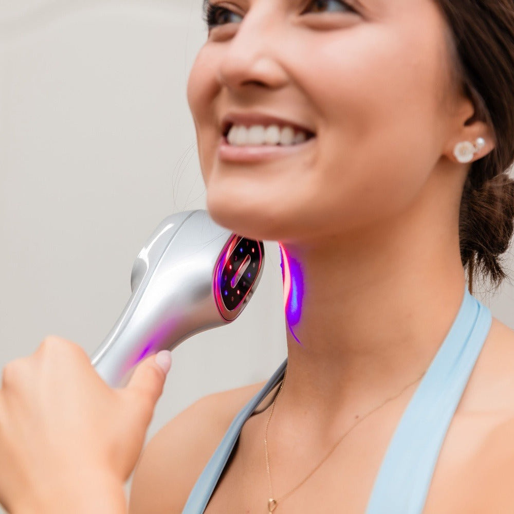Woman using a handheld device on her neck with a blurred background